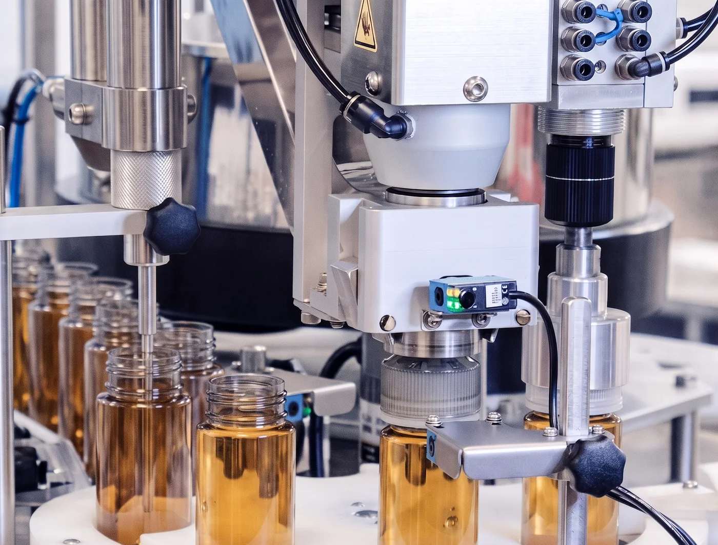 Automated filling machine with amber glass vials and robotic sensor arm
